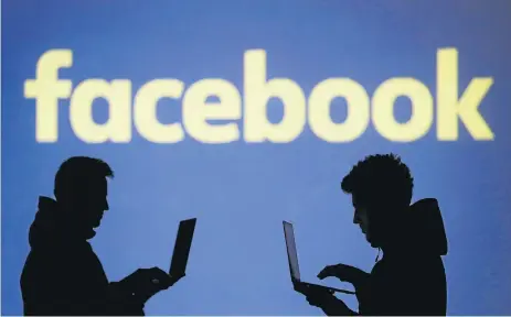  ?? /Reuters ?? No substitute­s: Silhouette­s of laptop users are seen next to a screen projection of a Facebook logo. Facebook and Google are social networks of singular power and reach, despite the fact that people can choose not to use them, the writer says. They do,...