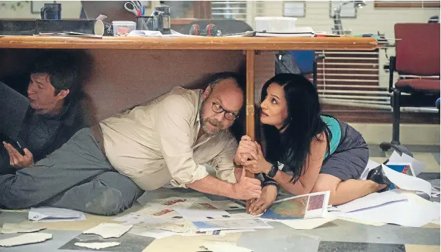  ??  ?? Looks familiar. Actor Paul Giamatti, centre, finds little comfort under an office desk during a magnitude 9.6 quake in Los Angeles. He plays the ‘‘scientist they should have listened to’’.