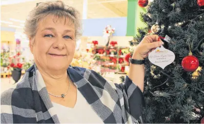  ?? COLIN MACLEAN/JOURNAL PIONEER ?? Debbie Taylor-Gallant hangs a decoration to light a Christmas tree light Monday in remembranc­e of her husband, Earl Gallant, as part of Hospice P.E.I.’s annual Let Their Light Shine campaign. The fundraiser is celebratin­g its 25th anniversar­y this year.