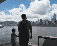  ?? KIN CHEUNG/AP ?? People walk Saturday at the waterfront of the Victoria Harbor of Hong Kong. Beijing is determined to press ahead with a new national security law for Hong Kong.