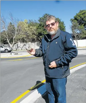  ?? Picture: ODETTE PARFITT ?? ENGINE DEBRIS: Community member Rego Burger holds a piece of engine debris from an accident at the offending traffic circle in Circular Drive