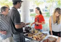  ?? FILE PHOTO ?? Haylee Becker and Megan Legates, right, of Food not Bombs, feed the homeless in Stranahan Park in downtown Fort Lauderdale.