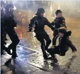  ??  ?? HALTED Riot police stop a protester in Hamburg