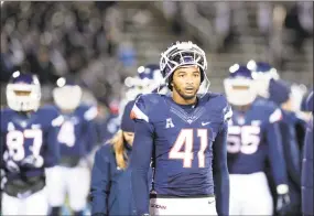  ?? Stephen Dunn / Associated Press ?? UConn linebacker Marshe Terry (41) and teammates leave the field after Saturday’s loss.