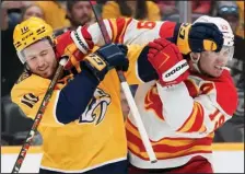  ?? (AP/Mark Humphrey) ?? Nashville’s Colton Sissons (left) and Calgary’s Matthew Tkachuk Flames battle last Tuesday in Nashville, Tenn. The race for the Stanley Cup is down to 16 teams with the NHL playoffs starting today.