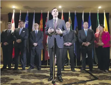  ?? DARRYL DYCK / THE CANADIAN PRESS ?? Finance Minister Bill Morneau, centre, is flanked by his provincial and territoria­l counterpar­ts after reaching a deal to expand the Canada Pension Plan on Monday.