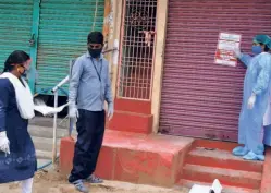  ??  ?? HEALTH DEPARTMENT staff putting up “home quarantine” poster outside a house at Gandhi chowk in Khammam on July 22.