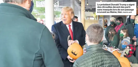  ?? PHOTO AFP ?? Le président Donald Trump a signé des citrouille­s devant des partisans masqués lors de son passage à Levant au Maine, hier.