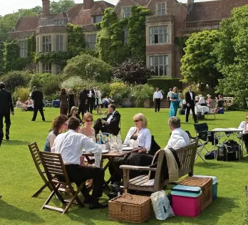  ??  ?? Magical setting: Enjoying a picnic with friends in the lovely gardens at Glyndebour­ne