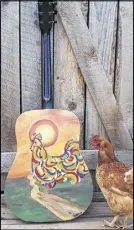  ?? SUBMITTED ?? One of the hens at Jackie Waugh’s home gives the guitar she painted a cluck of approval. The guitar will be part of Artists in Harmony, which will raise money for charities.