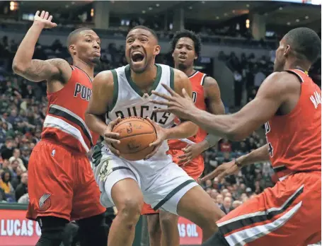  ?? ASSOCIATED PRESS ?? Jabari Parker of the Bucks works his way through a trio of Blazers defenders on his way to the basket for two of his team-high 27 points Wednesday.