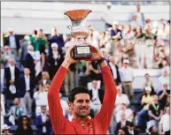  ?? Alessandra Tarantino / Associated Press ?? Serbia’s Novak Djokovic holds up the trophy after winning the final match against Greece’s Stefanos Tsitsipas at the Italian Open Sunday in Rome.