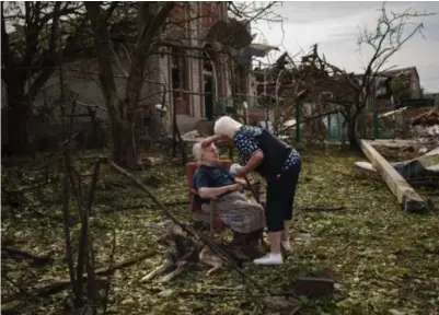  ?? BERNAT ARMANGUE / AP / NTB ?? En eldre kvinne får hjelp av en nabo utenfor ruinene av hjemmet sitt i Druzjkivka i østlige Ukraina som ble ødelagt av rakettangr­ep i juni i fjor.