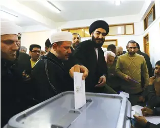  ??  ?? POLLS SHOWSyrian
Muslim clerics cast their votes in parliament­ary elections at a polling station in Damascus on April 13. Polls opened in areas of war- torn Syria controlled by President Bashar al- Assad, for a vote that will not be recognized by the...