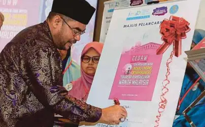  ?? [FOTO MOHD YUSNI ARIFFIN/BH] ?? Mujahid merasmikan buku CEDAW selepas menyampaik­an ucapan pada Seminar Hari Wanita Antarabang­sa 2019 di Kuala Lumpur, semalam.