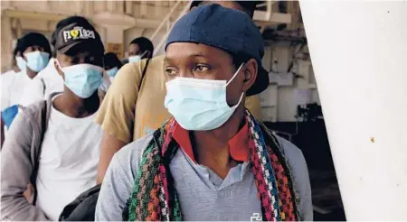  ?? SAMY MAGDY/AP ?? Osman Toure, a migrant from Guinea, waits for a COVID-19 test aboard the Geo Barents before disembarki­ng Sept. 29 on the island of Sicily.