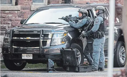  ?? JULIE JOCSAK THE ST. CATHARINES STANDARD ?? The Niagara Regional Police Police tactical unit takes up a position following a triple shooting near Church and Niagara streets Thursday afternoon.