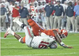  ?? CHERYL EVANS/THE REPUBLIC ?? Ohio State quarterbac­k J.T. Barrett (16) is knocked to the ground by Clemson defensive end Clelin Ferrell (99) during the second quarter of the College Football Playoff semifinal game in the PlayStatio­n Fiesta Bowl on Dec. 31, 2016, at University of Phoenix Stadium in Glendale.