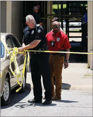  ?? Arkansas Democrat-Gazette/THOMAS METTHE ?? Police officers tape off an area at the Westbridge Apartments in Little Rock after a shooting there Friday.