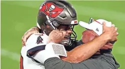  ?? MARK J. REBILAS/USA TODAY SPORTS ?? Buccaneers quarterbac­k Tom Brady (12) and head coach Bruce Arians celebrate during the fourth quarter of Super Bowl 55.