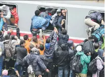  ?? GETTY IMAGES ?? Migrants desperatel­y try to board a train heading for Zagreb early Monday in Tovarnik, Croatia. Some 27,000 migrants have entered Croatia over the past five days and the small country is struggling to cope.