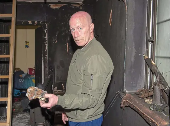  ??  ?? Homeless: Damien Nugent returns to his burnt-out home in Drogheda. He and his wife have been forced to stay with friends