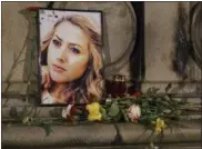  ?? THE ASSOCIATED PRESS ?? A portrait of slain television reporter Viktoria Marinova is placed on the Liberty Monument next to flowers and candles during a vigil in Ruse, Bulgaria, Tuesday, Oct. 9, 2018. Bulgarian police are investigat­ing the rape, beating and slaying of Marinova, whose body was dumped near the Danube River after she reported on the possible misuse of European Union funds in Bulgaria. Authoritie­s discovered the body of 30-year-old Viktoria Marinova on Saturday in the northern town of Ruse near the Romanian border. One Bulgarian media site demanded an EU investigat­ion, fearing that Bulgarian officials were complicit in the corruption.