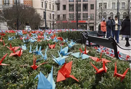  ?? — AP ?? A symbol of peace: People standing near a thousand paper cranes in front of the Norwegian Parliament in Oslo. ICAN installed the paper cranes made by children in Hiroshima, ahead of formally receiving the prize.