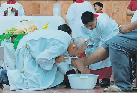  ?? ?? El padre Ricardo Ruiz Sacramento besa el pie de un vecino de Chicxulub que representó a uno de los apóstoles al que Jesucristo le lavó los pies en señal de humildad