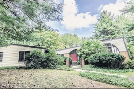  ?? Photos by Natalia Rodriguez ?? The brick-and-cedar-clad house at 855 Avon Crest Blvd. in Niskayuna features an eye-catching roof line. The home’s entrancewa­y features double doors and arches.