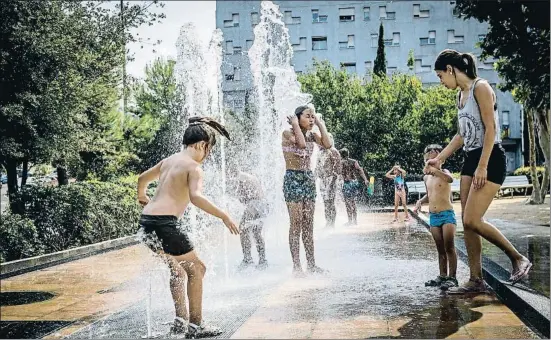  ?? LLIBERT TEIXIDÓ ?? Un grupo de personas, en su mayoría niños, combatiend­o las altas temperatur­as ayer en una fuente en Barcelona