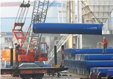  ??  ?? Chinese workers loading steel pipes at a port in Lianyungan­g, east China’s Jiangsu province. China’s manufactur­ing activity expanded at its quickest pace in nearly four years in December, an independen­t research firm said yesterday. — AFP