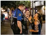  ??  ?? Lee, who is in charge of the officers on Sixth Street, talks to Amanda Patrick (center) and Abby Sutton. “We just don’t have a whole lot of fights anymore” on the street, Lee said.