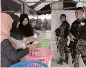  ?? — AFP ?? Soldiers stand guard as electoral officials count votes at a polling station in Bangkok on Sunday after polls closed in Thailand’s general election.