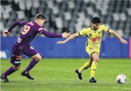  ?? PHOTOS: GETTY IMAGES ?? Leading the way . . . New Phoenix captain Ulises Davila shoots for goal during the side’s ALeague eliminatio­n final against the Perth Glory in Sydney in August last year, as Perth midfielder Kristian Popovic closes in. Below: Phoenix assistant coach Chris Greenacre talks to players during a training session in Wellington last season.