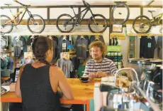  ??  ?? Above left: Michelle Powell serves coffee to Warren Dean at the Over the Edge bikes and coffee shop on Ski Run Boulevard in South Lake Tahoe.