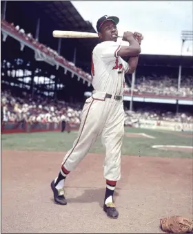  ?? Associated Press ?? Legend dies: In this 1954 file photo, Milwaukee Braves' Hank Aaron poses for a photo at Ebbets Field during an exhibition season in New York. Aaron, who endured racist threats with stoic dignity during his pursuit of Babe Ruth but went on to break the career home run record in the pre-steroids era, died early Friday. He was 86. The Atlanta Braves said Aaron died peacefully in his sleep. No cause of death was given.