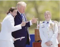  ?? — Reuters ?? US President Donald Trump poses for a photograph with Ensign Erin Reynolds (L) after presenting her commission at the US Coast Guard Academy commenceme­nt in New London, Connecticu­t on Wednesday.