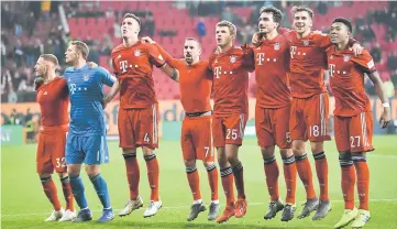  ??  ?? File photo shows Bayern Munich players celebrate in front of the fans at the end of the match between FC Augsburg and Bayern Munich. — Reuters photo