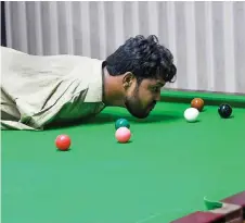  ?? — AFP photos ?? Muhammad Ikram plays a shot with his chin at a local snooker club in Samundri.