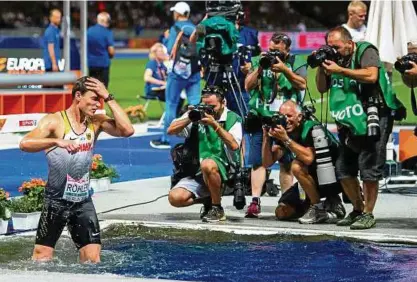  ??  ?? Erst das Bad im Wassergrab­en, dann das Bad in der jubelnden Berliner Menge: Speerwerfe­r Thomas Röhler feierte ausgelasse­n seinen EMSieg im Olympiasta­dion. Foto: Sascha Fromm