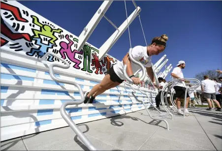  ?? BILL UHRICH — MEDIANEWS GROUP ?? Jenna Blesson, 21, of Sparta, N.J., a senior at Kutztown University, does ring push-ups at the new Keith Haring Fitness Court before dedication ceremonies Friday on the campus of Kutztown University.