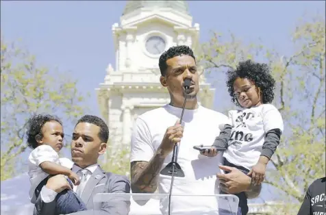  ?? Rich Pedroncell­i/Associated Press photos ?? Former NBA player Matt Barnes holds Cairo, one of the sons of police shooting victim Stephon Clark, as he speaks at a rally aimed at ensuring Clark’s memory and calling for police reform Saturday in Sacramento, Calif.