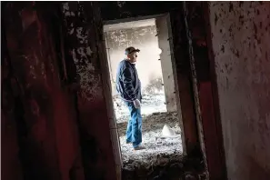  ?? AP Photo/Bernat Armangue ?? Serhii Klochko, 54, inspects his neighbor’s apartment that was damaged Saturday during shelling in Kharkiv, eastern Ukraine.