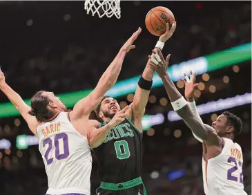  ?? Maddie Meyer/Getty Images ?? The Boston Celtics’ Jayson Tatum takes a shot against Dario Saric (20) of the Phoenix Suns and Deandre Ayton at TD Garden on Feb. 3 in Boston.