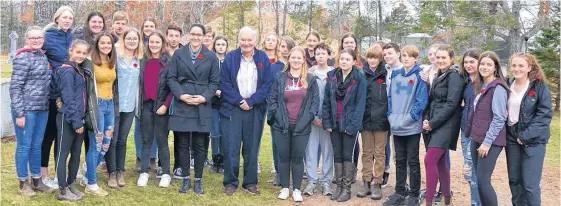  ?? LAWRENCE POWELL PHOTOS ?? Teacher Laura Cole and Middleton resident John MacEachern stand with MRHS students after a ceremony at the Commonweal­th War Graves in Middleton.
