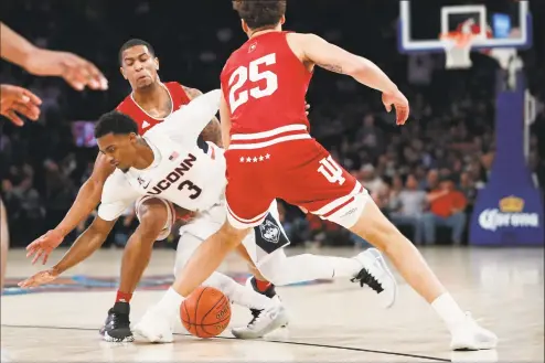  ?? Kathy Willens / Associated Press ?? UConn’s Alterique Gilbert (3) gets tangled up with Indiana’s Devonte Green (11) and loses the ball as Indiana’s Race Thompson (25) looks on during the first half of Tuesday’s game in the Jimmy V Classic at Madison Square Garden in New York.