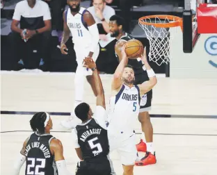  ?? Kim klement / pool photo via ap ?? José Juan Barea se eleva sobre la defensa de los Kings para intentar un tiro durante el partido de ayer en la burbuja de la NBA.