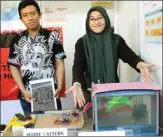  ?? BRIANIKA/JAWA POS ?? KARYA MAHASISWA: Putria (kanan) menjelaska­n inovasi rekayasa cahaya laser dengan kombinasi tiga cermin datar.