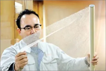 ?? KAZUHIRO NOGI/AFP ?? Hidaka Washi president Hiroyoshi Chinzei, a fourth-generation traditiona­l paper maker, displays the world’s thinnest paper at his factory in Hidaka, Kochi prefecture.